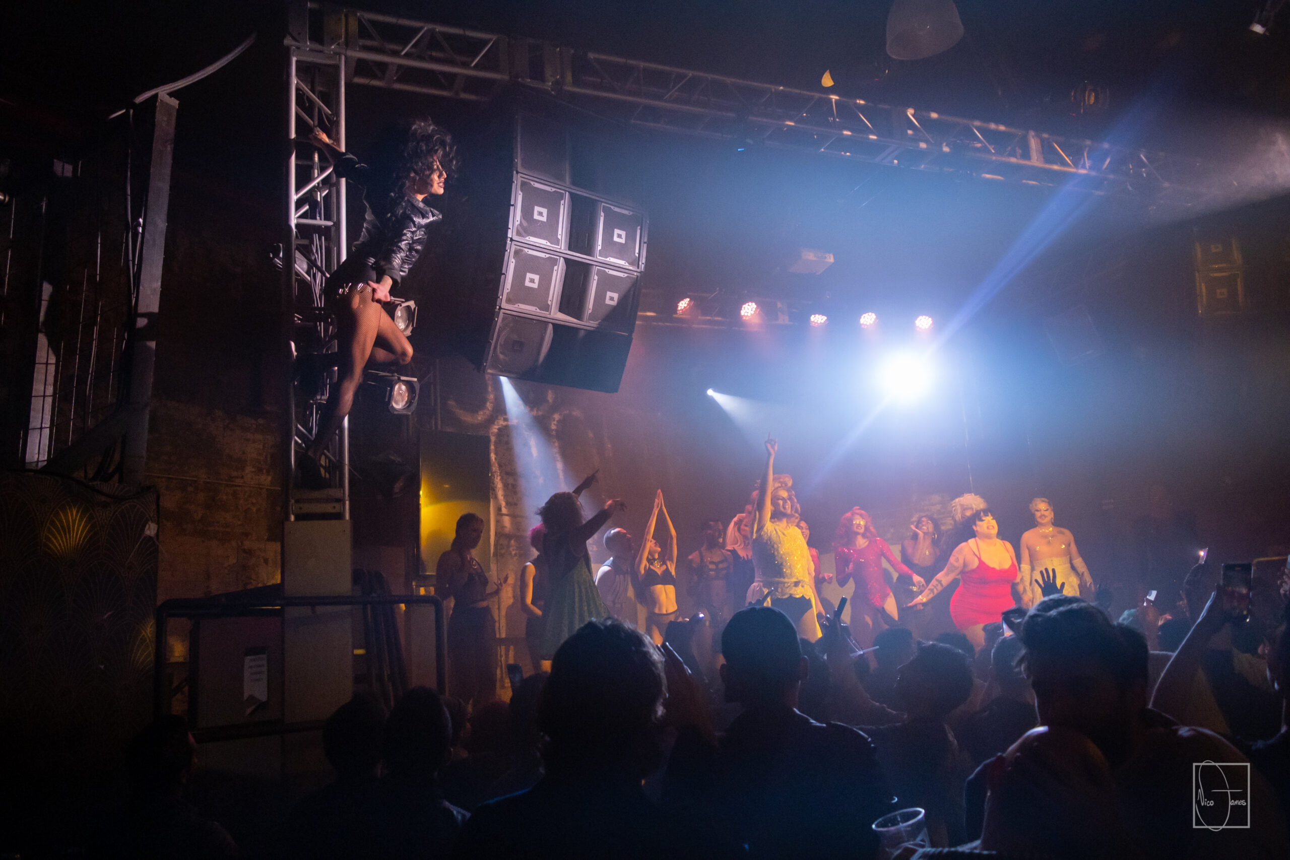 Multiple people on stage and one person climbing the scaffolding.